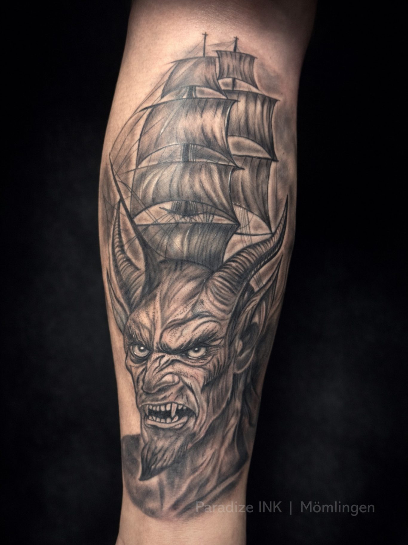 Paradize INK Tattoo Mömlingen Tattoo eines geflügelten Wesens mit einem Schiff im Hintergrund.