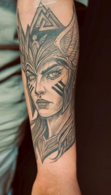 Tattoo eines weiblichen Charakters mit markanten Gesichtszügen und künstlerischem Design.