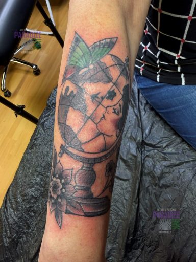 Tattoo eines Globus mit einer Blumenranke und einer Schmetterlingsflügel.