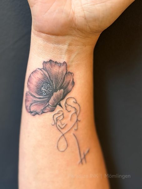 Tattoo eines Blumenmotivs mit geschwungener Linie und minimalistischer Ästhetik.