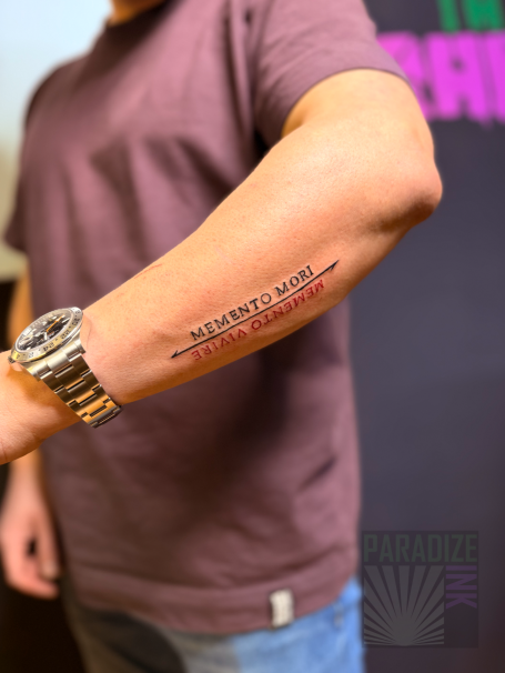 Tattoo auf dem Unterarm mit dem Text "NEVER GIVE UP".