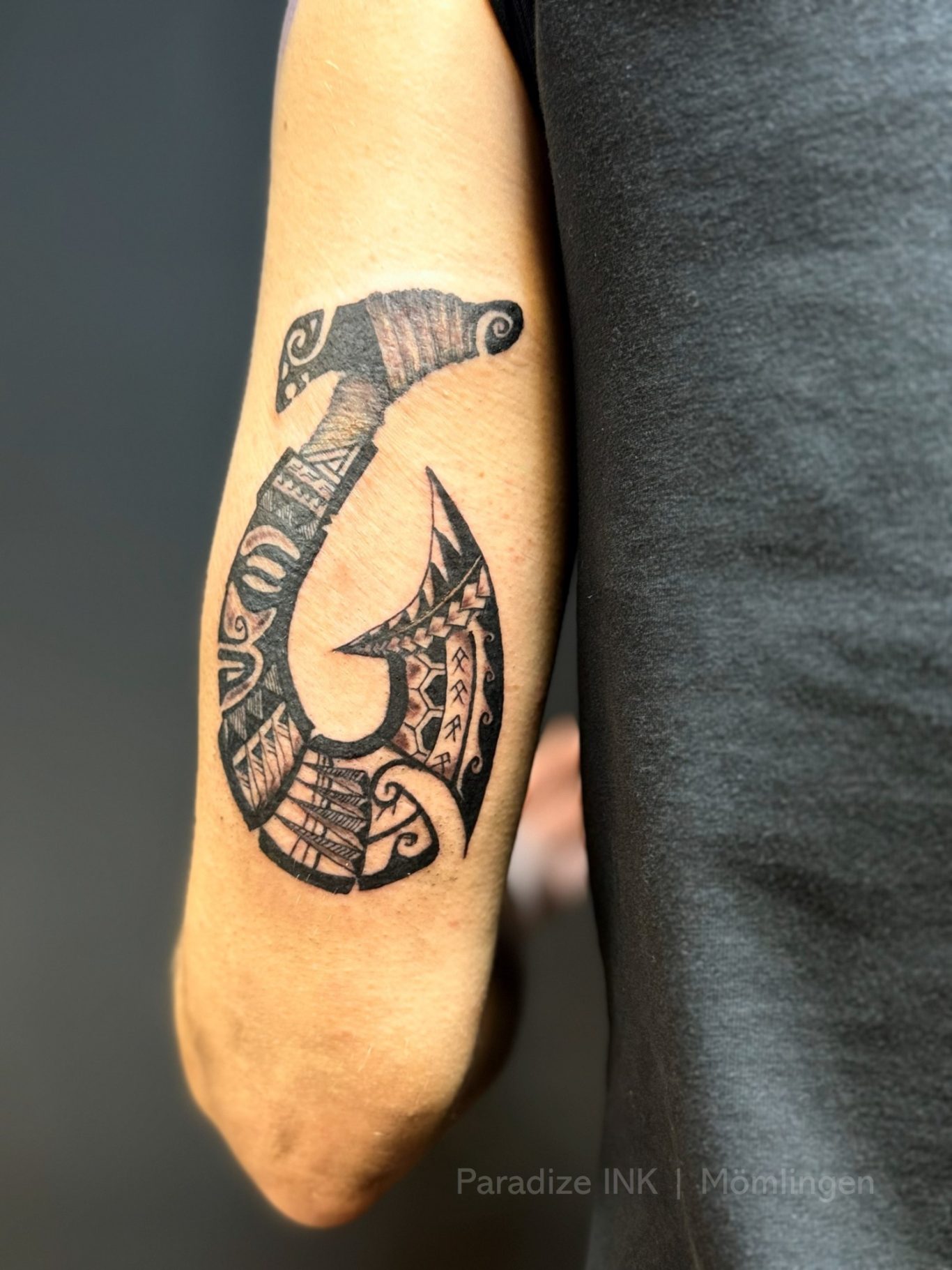 Paradize INK Tattoo Mömlingen Schwarzer Tattoos mit einem stilisierten Skorpion-Design auf einem Unterarm.