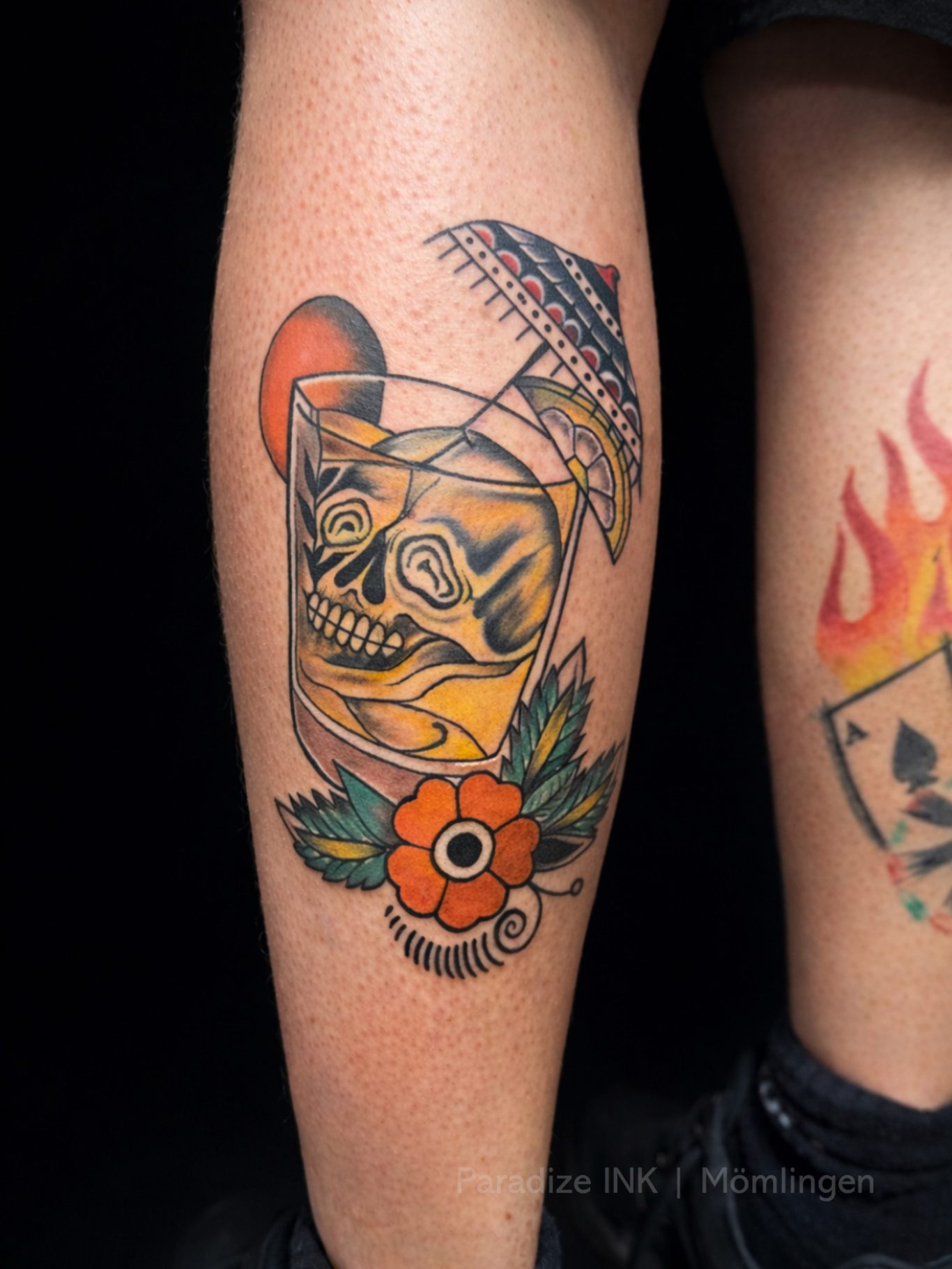 Paradize INK Tattoo Mömlingen Tattoo eines Schädels in einem Glas mit einer blühenden Blume und einem kleinen Schirm.